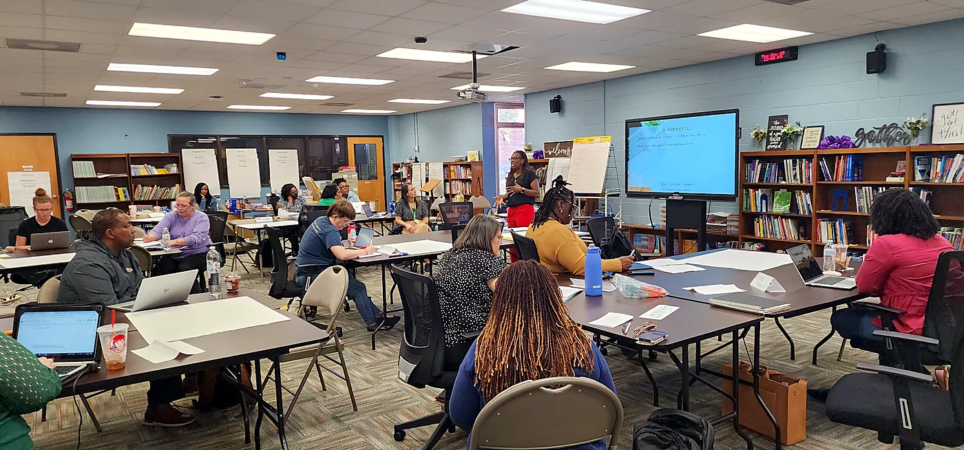 Jocelynn leading a professional learning session with a room of educators